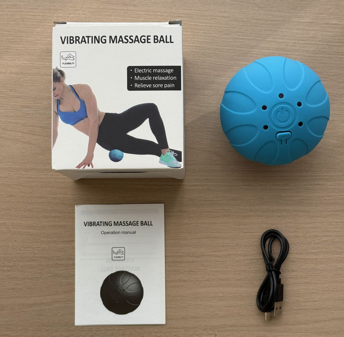 Bola de masaje azul con su caja y cable de carga